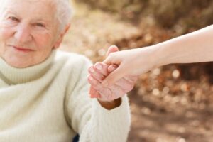 carer graphicstock-elderly-woman-holding-hands-with-young-woman-outside_HYmZxeWBXO-