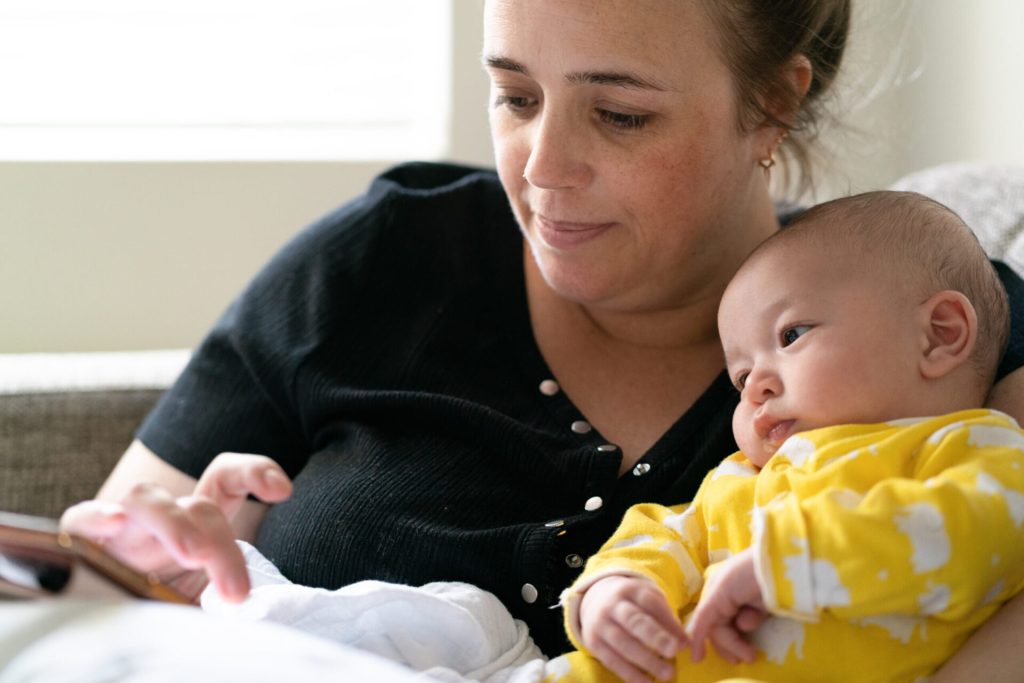 Mother shopping online with young mixed-race baby