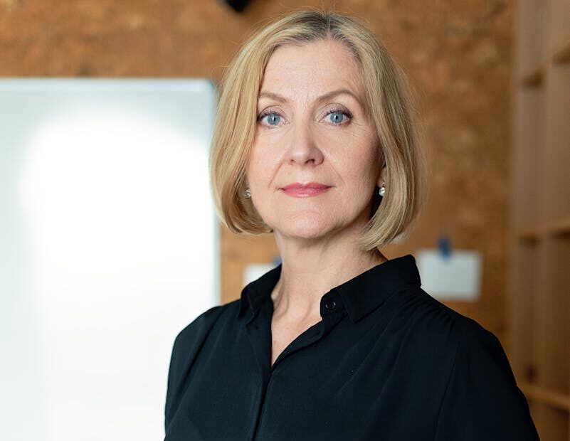 Confident mature businesswoman in office attire posing confidently indoors.