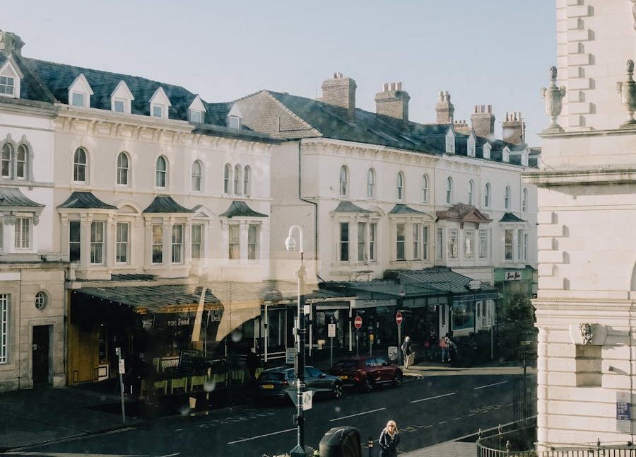 Sunlit street scene in Llandudno, Wales, showcasing historic architecture and a bustling atmosphere.